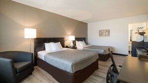 A hotel room with two beds, a desk, a chair, and a lamp. - Econo Lodge Auburn I-95 (Auburn)