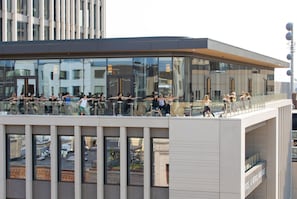 A modern building with a glass balcony where people are stretching.