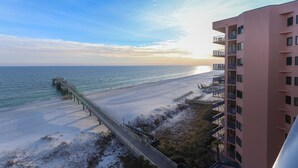 A beach view with a pier, a pink building, and a clear sky. - Four Seasons 703E by Liquid Life (Orange Beach)