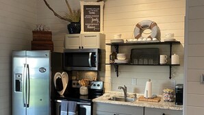 Una cocina moderna con electrodomésticos de acero inoxidable, encimera de granito y un letrero decorativo sobre el lavamanos.