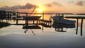 Una marina tranquila al atardecer con barcos amarrados a muelles de madera.
