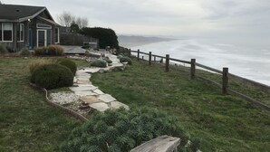 A coastal property with a stone pathway leading to a wooden fence overlooking the ocean. - Enter the "Garage House" and step into sublime ocean front living. (Trinidad)