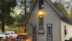 Ein weißes Gebäude mit einem Schild mit der Aufschrift "Creekside Hideaway", einer umzäunten Veranda und einem Sicherheitshinweisschild.