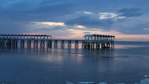 A pier extending into calm waters with a sunset in the background. - Sea-Esta Retreat, a Great Golden Isles Location! (St. Simons Island)