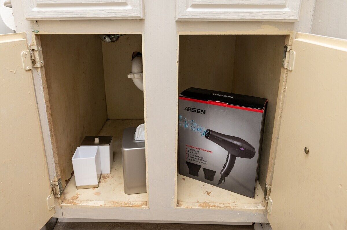 Un baño con un lavabo blanco, un espejo y un secador de pelo Arsen.