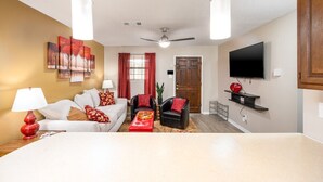 A living room with a sofa, two armchairs, a coffee table, a TV, and artwork on the wall. - Near Hospitals | P&G | 3 TVs | King 🛏 | PetsOK🐩 (Pineville)