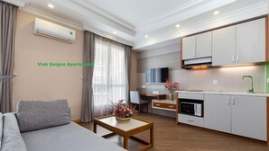 A modern apartment with a sofa, a dining area, and a kitchen. - Vinh Saigon SECC 2 (Ho Chi Minh City)