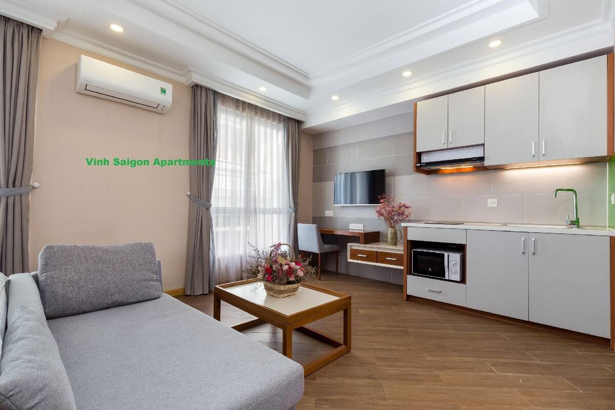 A modern apartment with a sofa, a dining area, and a kitchen.