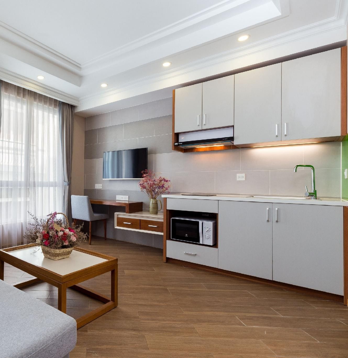 A modern apartment with a sofa, a dining area, and a kitchen.