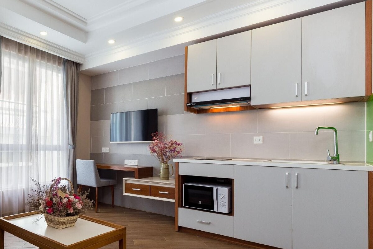 A modern apartment with a sofa, a dining area, and a kitchen.