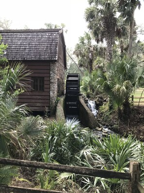 A rustic wooden building with a stone wall and a small waterfall. - Nature Lover’s Cottage at Penner Pond, Relax or Explore in the Ocala Forest. (Fort McCoy)