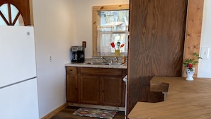 Una cocina con armarios de madera, un refrigerador, una ventana con vistas y una encimera de madera.