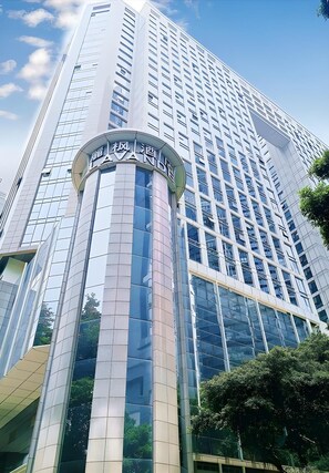 A modern high-rise building with a prominent cylindrical section featuring signage. - Lavande Hotel (Guangzhou)