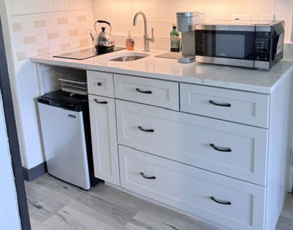 A kitchen with a dishwasher, a microwave, and a sink.