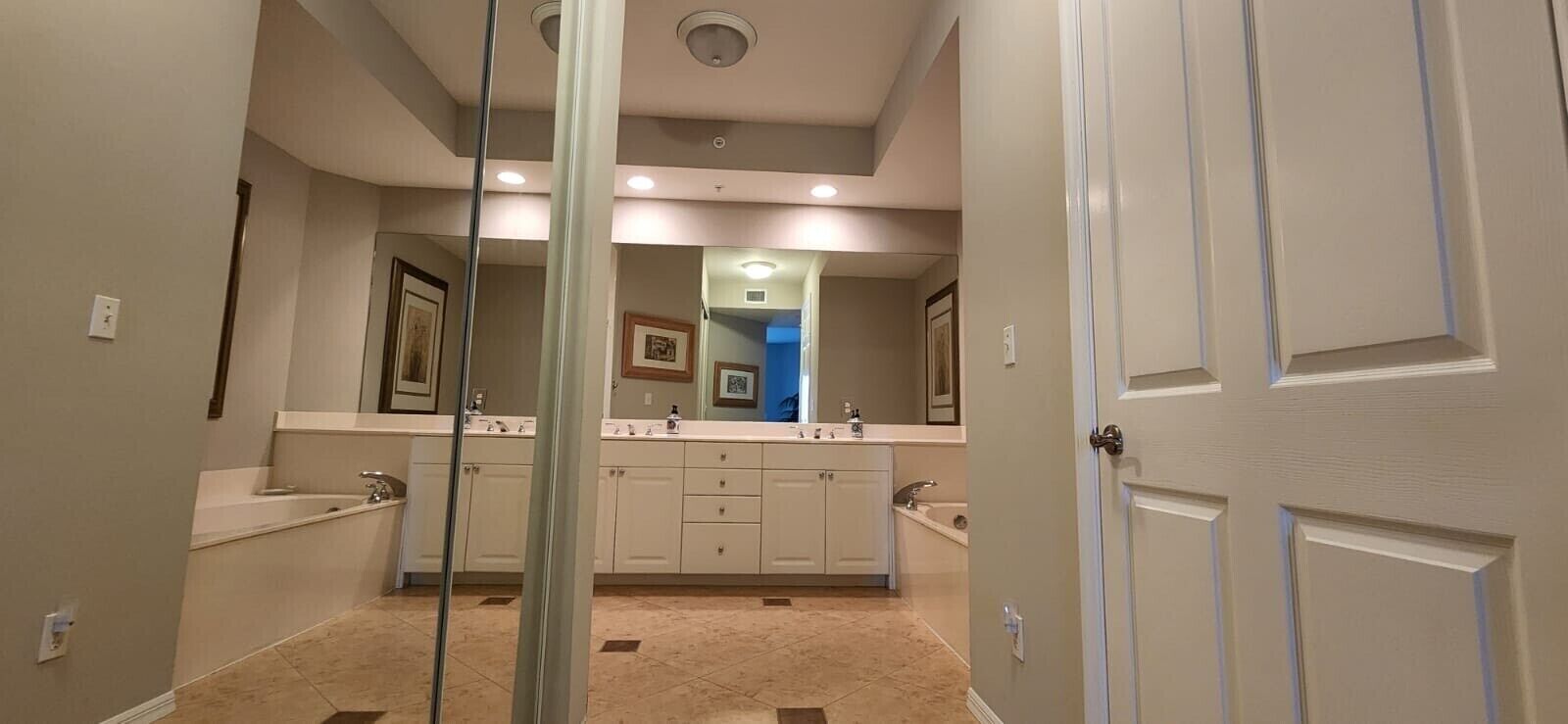 Een moderne badkamer met een wastafelmeubel met dubbele wastafel, een grote spiegel en een inloopdouche.