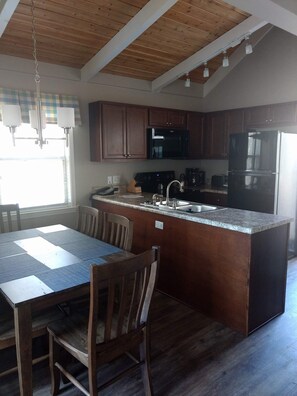 Enjoy cooking in this well-equipped kitchen with a central island, appliances, and a large window.