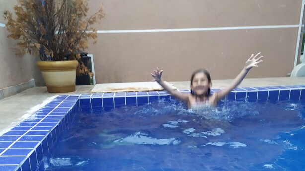 Ein Swimmingpool mit blauen Fliesen und einer Pflanze im Blumentopf daneben.