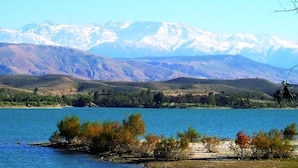 Un llac amb muntanyes al fons i una petita illa amb arbres a primer pla.
