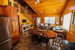 Cozy cabin with a large dining table, comfortable living area, and kitchen amenities.