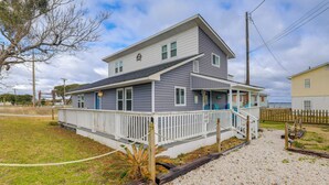 A two-story house with a white porch and a small deck. - Walkable & Renovated! Salter Path Retreat w/ Deck (Atlantic Beach)