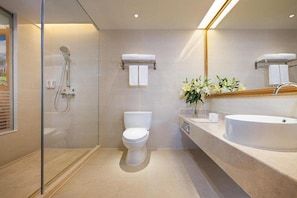 A modern bathroom with a glass shower enclosure, a toilet, and a large sink with a mirror above. - Venus International Hotel Shenzhen Gongming Square Metro Station Tianhong Branch (Shenzhen)
