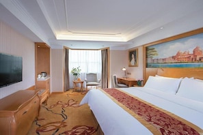 A hotel room with a large bed, a desk, a chair, a television, and a painting on the wall. - Venus International Hotel Shenzhen Gongming Square Metro Station Tianhong Branch (Shenzhen)