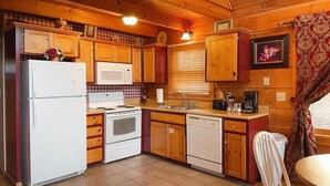 A compact kitchen with wooden cabinets, a refrigerator, a microwave, a stove, and a sink. - Mountain Views ** Close2 Parkway/Gatlinburg/Dollywood ** | TreeHouse  (Sevierville)