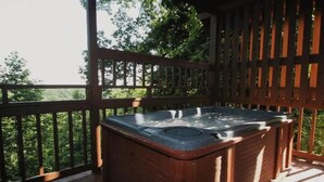 A hot tub on a wooden deck with a view of trees. - Mountain Views ** Close2 Parkway/Gatlinburg/Dollywood ** | TreeHouse  (Sevierville)