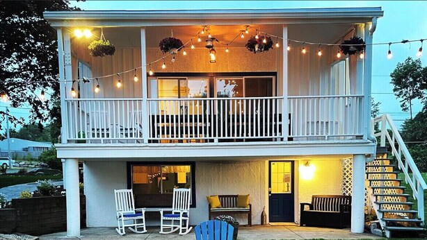 A two-story house with a balcony, outdoor seating, and a fire pit. - Private beach; firepit, outdoor shower, AC, two kitchens, laundry, covered patio (Narragansett)