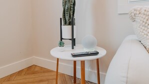 A small white table with a potted plant, a remote control, and a white spherical object. - The Loft w/outdoor fire pit (Grandville)
