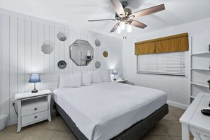 A bedroom with a large bed, two bedside tables with lamps, a ceiling fan, and a window with blinds. - SunDestin 1BR Beach Retreat With Relaxing Gulf-Front Balcony - Unit 0306 (Destin)