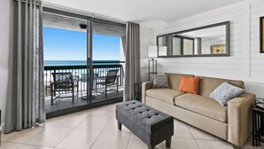 A room with a sliding glass door leading to a balcony with a view of the sea. - SunDestin 1BR Beach Retreat With Relaxing Gulf-Front Balcony - Unit 0306 (Destin)