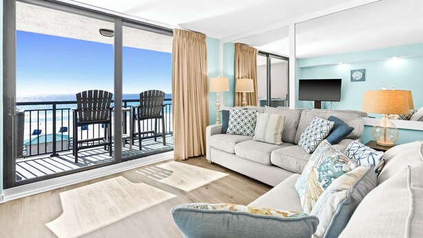 A spacious living room with a large sliding glass door leading to a balcony overlooking the beach. - SunDestin 1BR Condo With Tropical Style and Gulf Sunsets - Unit 0408 (Destin)