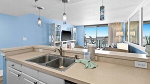 A modern kitchen with a large island, stainless steel appliances, and a view to the outside. - SunDestin Beach Resort Getaway With Pool, Hot Tub and Gulf Access (Destin)