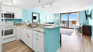 A modern kitchen with white cabinets, a granite countertop, and a large island.