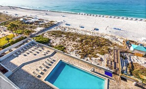 A resort with a swimming pool, beach access, and a view of the ocean.