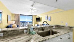 Una cucina con piano di lavoro in marmo, lavello e ventilatore a soffitto.