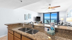 A kitchen with granite countertops, a sink, and a ceiling fan. - SunDestin Beach Retreat With Balcony Views and Relaxed Family Comfort (Destin)