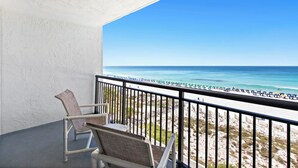 A balcony with a view of the beach, a chair, and a railing. - SunDestin Beach Retreat With Balcony Views and Relaxed Family Comfort (Destin)