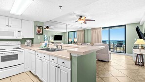 Una cocina moderna con una isla central, un comedor con vistas y un balcón con vistas.