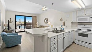 A modern kitchen with white cabinets, a central island with a sink, and a large oven. - SunDestin Ground-Floor 1BR With Easy Pool Access and Coastal Design (Destin)