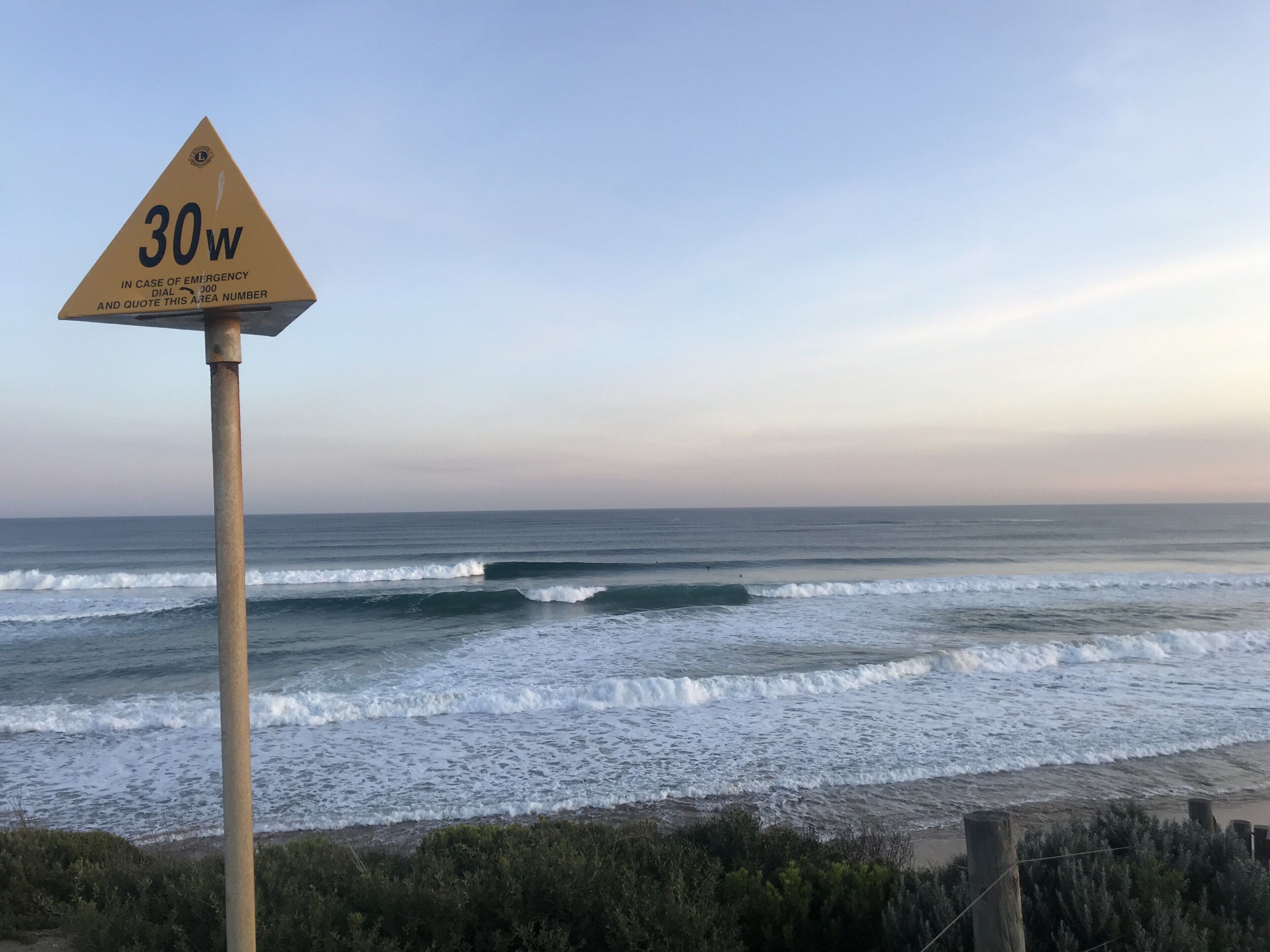 A beach scene with a triangular sign indicating a 30w area.
