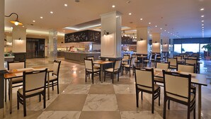 A spacious restaurant with marble flooring, multiple dining tables and chairs, and a central bar area. - Crystal Land Of Paradise Beach Hotel (Alanya)