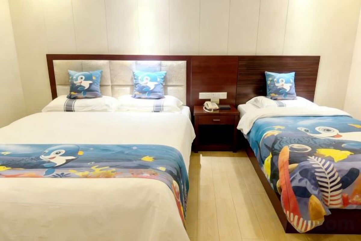 Une chambre d  ’hôtel avec deux lits simples, chacun doté d’une tête de lit et d’un oreiller assortis. Une table de chevet avec une lampe et un téléphone se trouve d’un côté.