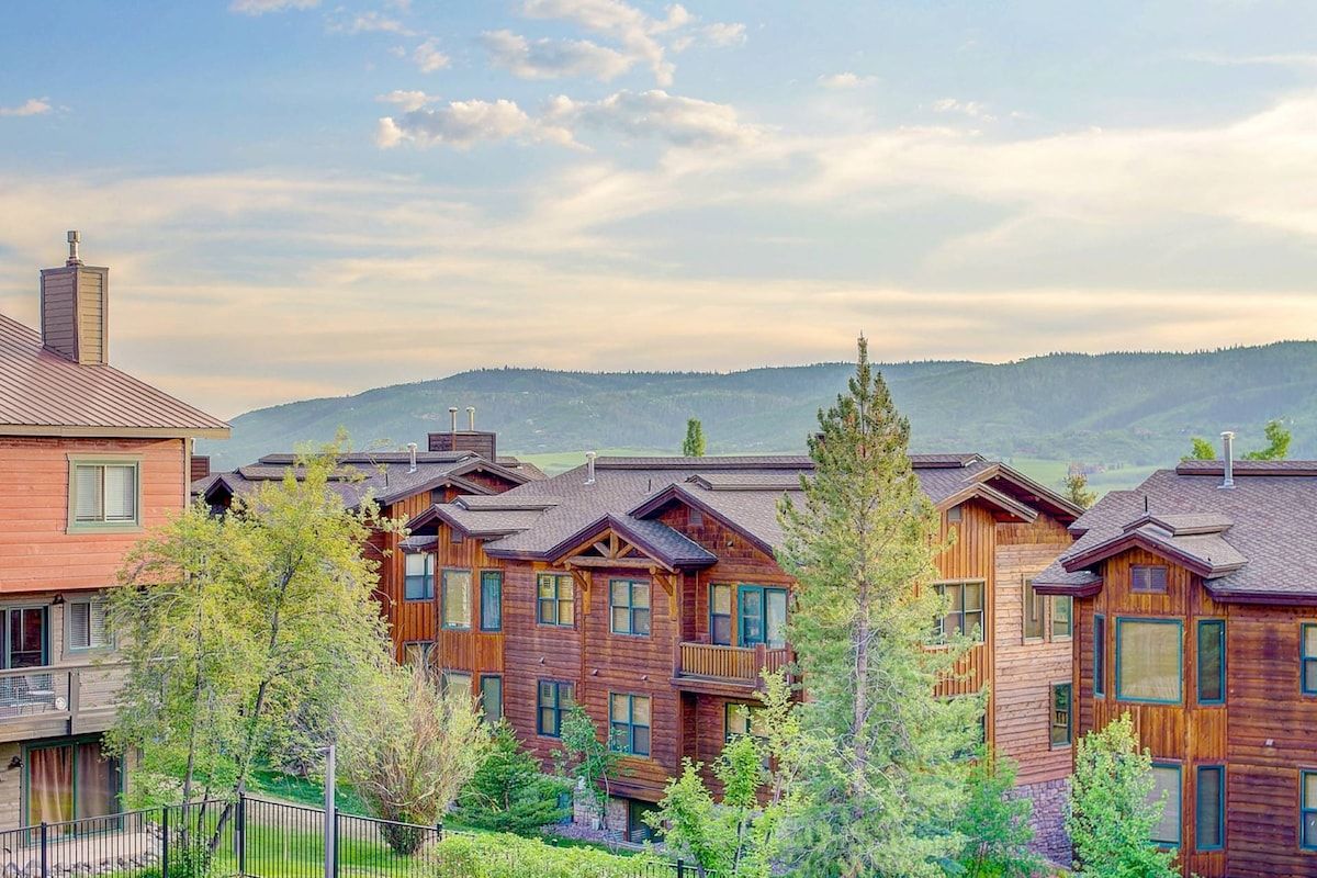 A row of wooden cabins with multiple stories, each featuring balconies and large windows.