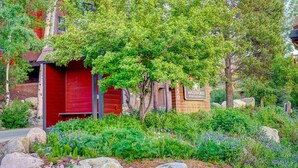 A red building with a sign reading "Waterford Townhomes." - 4 enSuites/2 King Beds-2 Car Garage-EZ Walk to Trails/Resort +Free Town Bus-W/D in Unit-Large Deck (Steamboat Springs)