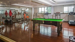 A spacious indoor area with a pool table, exercise equipment, and a treadmill. - Taishan Bojue Hotel (Jiangmen)