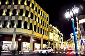 A multi-story building with illuminated windows and a street in front. - Taishan Bojue Hotel (Jiangmen)