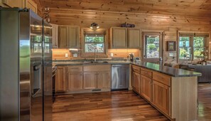 A modern kitchen with wooden cabinets, stainless steel appliances, and a central island.