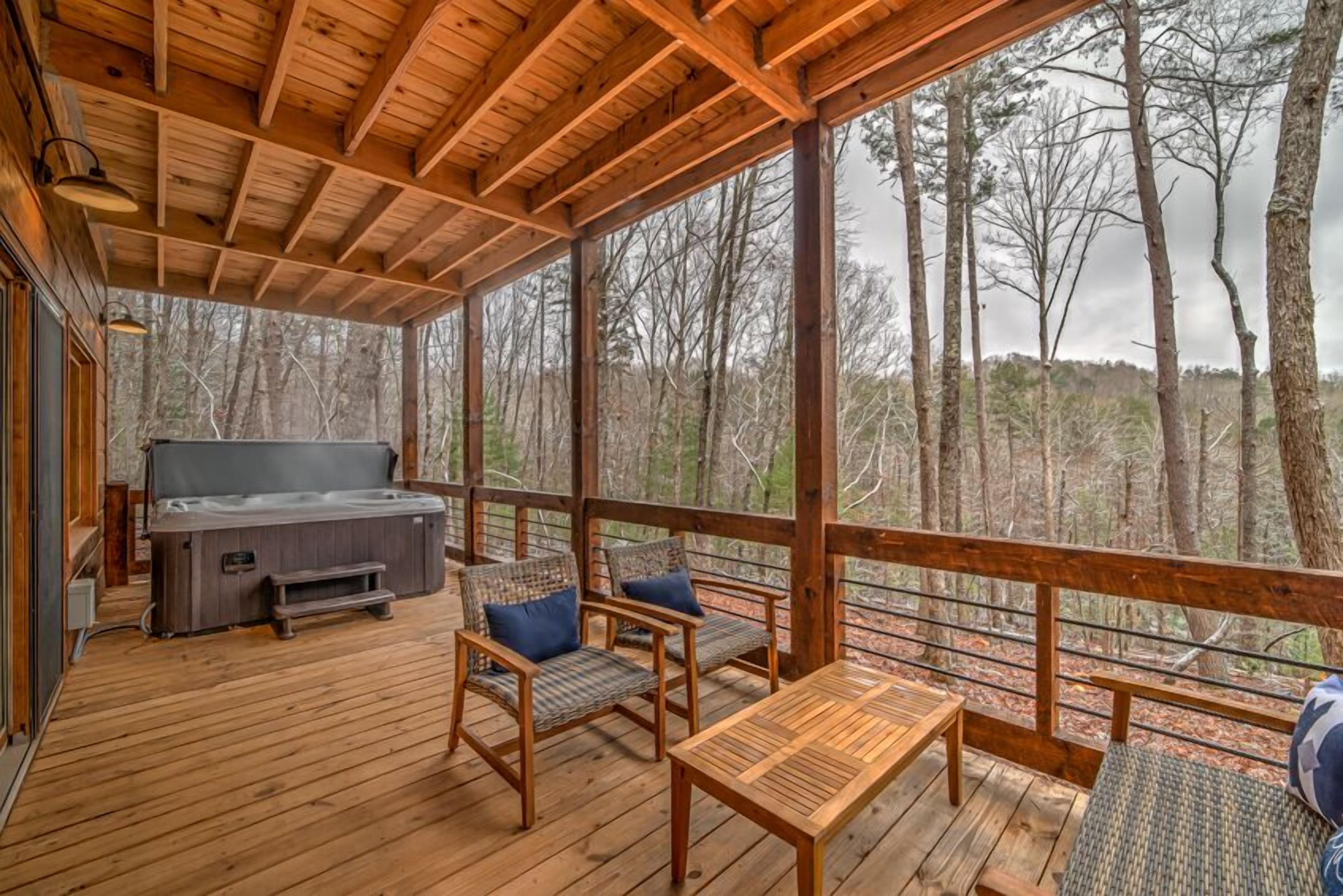A wooden deck with a hot tub, chairs, and a table.